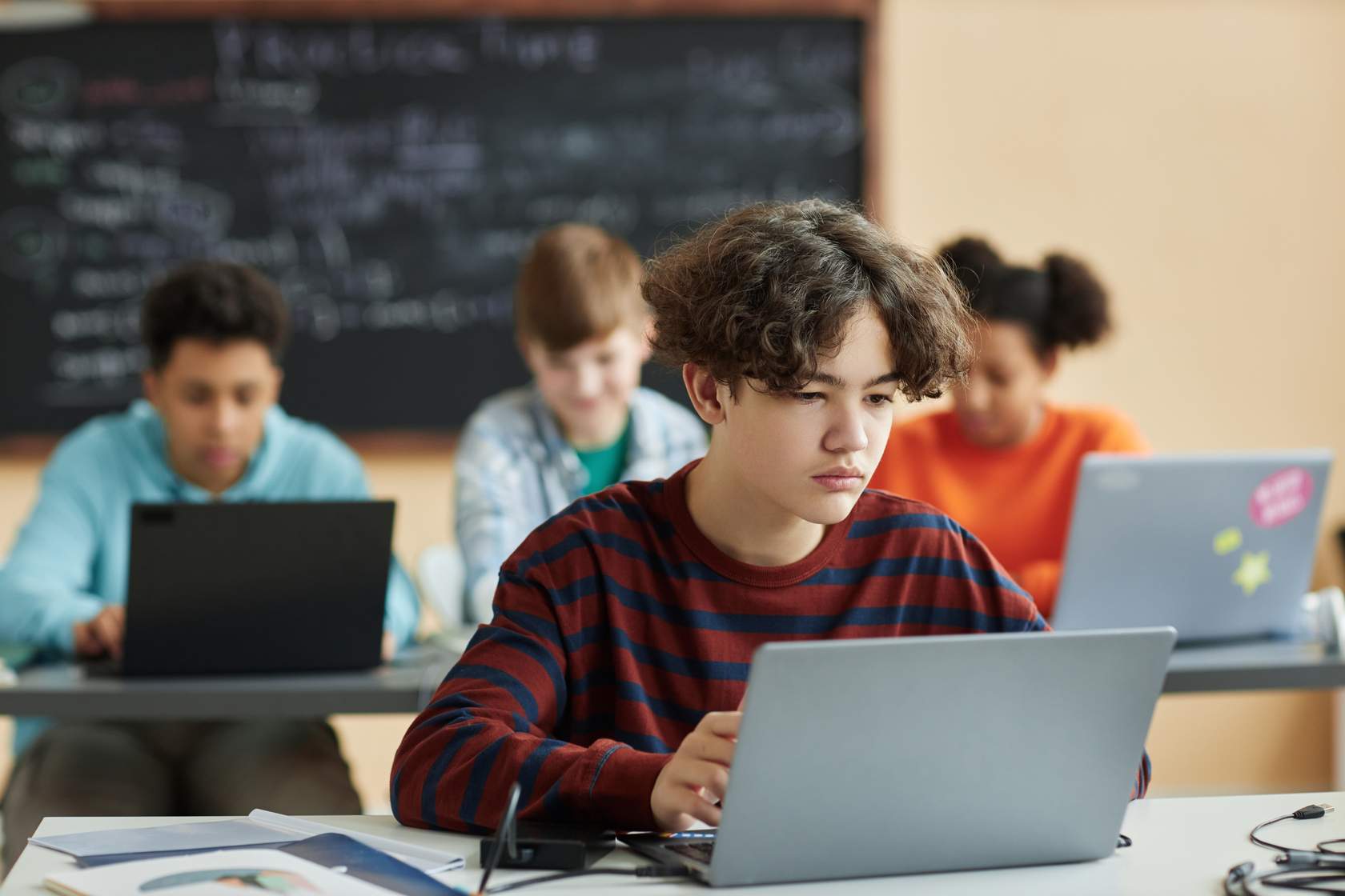 Students working on an Acer laptop which is the hero image for this cybersecurity in the age of AI course